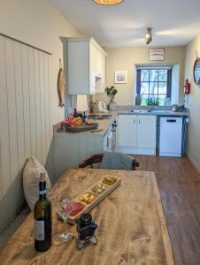 cocina con mesa y botella de vino en Lindisfarne Cottage, en Beadnell