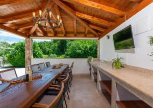 an outdoor dining room with a long table and chairs at Villa Vesna with tennis court in Pićan