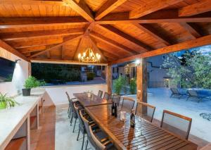 a wooden dining table and chairs under a wooden ceiling at Villa Vesna with tennis court in Pićan