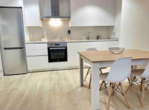een keuken met een houten tafel en witte kasten bij New Port, Free Parking YBH1L in Vigo