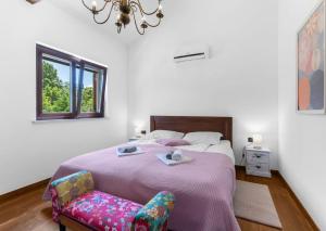 a bedroom with a bed with a chair and a chandelier at Villa Vesna with tennis court in Pićan +49 photos