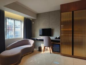 a hotel room with a couch and a desk with a television at Olive Le Opera by Embassy Group in Bangalore