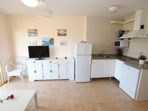 eine Küche mit weißen Schränken und einem weißen Kühlschrank in der Unterkunft Clara-154 in Salou