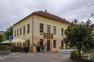 un gran edificio amarillo con techo rojo en Penzion Hacienda Ranchero en Pardubice