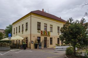 a large yellow building with a red roof at Penzion Hacienda Ranchero in Pardubice