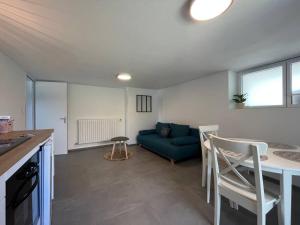 uma sala de estar com um sofá azul e uma mesa em Appartement Vannes avec jardin em Saint-Avé