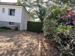 a backyard of a house with a hedge and flowers at Appartement Vannes avec jardin in Saint-Avé