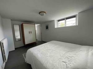 um quarto com uma cama branca e uma janela em Appartement Vannes avec jardin em Saint-Avé