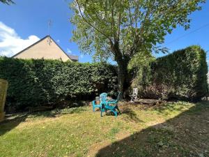 eine blaue Bank im Gras neben einem Baum in der Unterkunft Appartement Vannes avec jardin in Saint-Avé + 2 Fotos