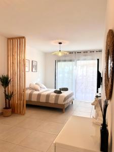 1 dormitorio con cama y ventana grande en Appartement neuf coup de coeur entre Èze et Monaco, en Èze