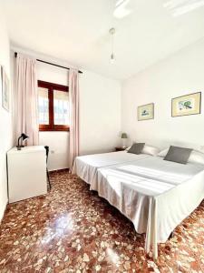 a white bedroom with a large bed and a window at Hispalis villa en Matalascañas in Matalascañas +34 photos