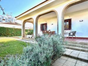 a white house with an archway and a patio at Hispalis villa en Matalascañas in Matalascañas