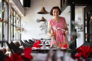 uma mulher de pé numa mesa num restaurante em Gastinger Hotel-Restaurant em Schmiedefeld am Rennsteig