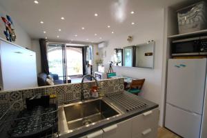 uma cozinha com um lavatório e um frigorífico em MARCOGVER - Golfe de St-Tropez - Studio pour 2 personnes vue sur la marina em Cogolin