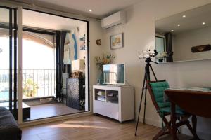 uma sala de estar com uma televisão e uma câmara em MARCOGVER - Golfe de St-Tropez - Studio pour 2 personnes vue sur la marina em Cogolin