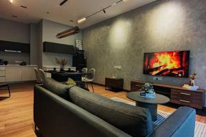 uma sala de estar com um sofá e uma lareira na parede em Premium Darkdesign 6pax In Desa ParkCity WifiTvbox em Kuala Lumpur