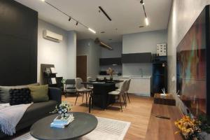 uma sala de estar com um sofá, uma mesa e uma cozinha em Premium Darkdesign 6pax In Desa ParkCity WifiTvbox em Kuala Lumpur