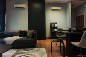 uma sala de estar com um sofá e uma mesa em Premium Darkdesign 6pax In Desa ParkCity WifiTvbox em Kuala Lumpur