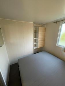 um quarto vazio com uma cama e uma janela em Ruime 5-persoons chalet aan het Bergumermeer em Suameer
