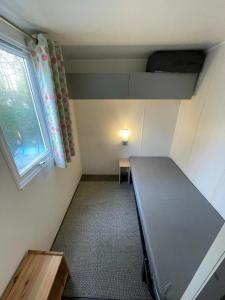 um pequeno quarto com uma cama e uma janela em Ruime 5-persoons chalet aan het Bergumermeer em Suameer