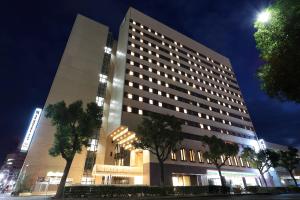 un gran edificio con árboles delante de él en SK HOTEL Kobe Ekimae en Kobe