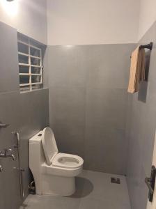 La salle de bains est pourvue de toilettes blanches et d'une fenêtre. dans l'établissement FULL MOON HOMES, à Cochin