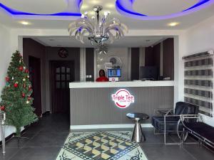 a woman standing at a counter with a christmas tree at Triple Tee Luxury Hotel & Service Apartments Surulere in Lagos