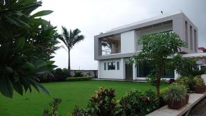 duży biały dom z zielonym dziedzińcem w obiekcie Chandanvan Club & Resort w mieście Jalālpur