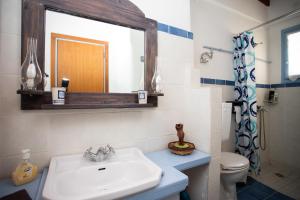 a bathroom with a sink and a mirror and a toilet at Patmos Houses Tennis & Beach Tennis Court's in Patmos