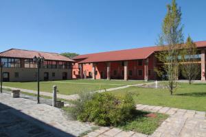 Top Residence Arioli في Ozzero: مبنى مدرسة أمامه ساحة عشبية