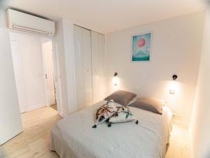 een slaapkamer met een bed in een witte kamer bij GASBRU - Golfe de St-Tropez - Rez de jardin T2 cabine avec accès plage piscine et tennis in Gassin