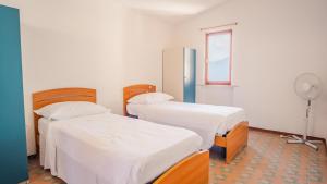 een ziekenhuiskamer met 2 bedden en een koelkast bij Villa Mirella - Italian Homing in Torri del Benaco