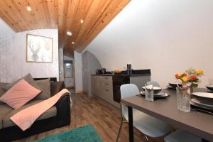 a living room with a couch and a table at Luxurious Family Pod with Garden and Hot tub - The Stag Hoose by Get Better Getaways in Glenluce