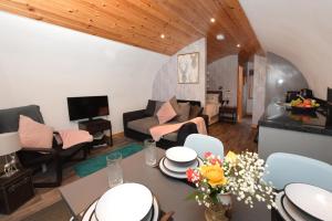 a living room with a couch and a table with flowers at Luxurious Family Pod with Garden and Hot tub - The Stag Hoose by Get Better Getaways in Glenluce