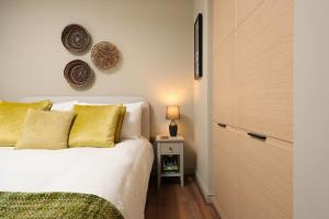 1 dormitorio con 1 cama y 1 mesa con lámpara en Stylish Flat With Sofa Bed in Malmesbury!, en Malmesbury