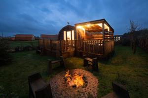 a gazebo with a fire pit in a yard at Luxurious Family Pod with Garden and Hot tub - The Stag Hoose by Get Better Getaways in Glenluce