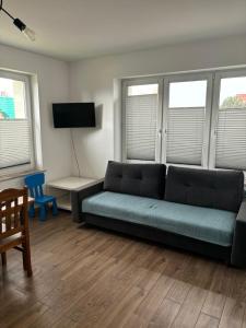 a living room with a couch and a table and windows at U Hrabiego in Krzeszowice