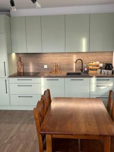 a kitchen with a wooden table and white cabinets at U Hrabiego in Krzeszowice