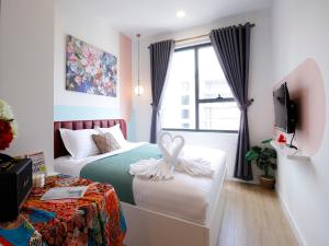 a bedroom with two beds and a tv and a window at May Soho Saigon Serviced Apartment in Ho Chi Minh City