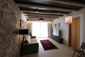salon z kanapą i telewizorem w obiekcie Drymades Inn Resort w mieście Dhërmi