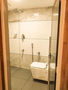 a bathroom with a toilet and a glass shower at Hotel Royal Wings in Elūr