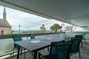 une table noire et des chaises sur un balcon dans l'établissement La Proue - Charmant appt vue mer, à Concarneau