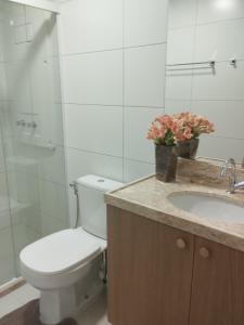 a bathroom with a toilet and a sink at Blue Beach pé na areia, Resort e praia in Cabedelo