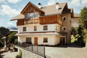 uma casa nas montanhas com uma varanda em Chalet La Flüta Arnica em La Valle