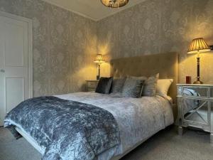 a bedroom with a large bed with two lamps at Pass the Keys Bijoux Central Bath Period Apartment and Parking in Bath