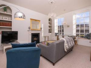 a living room with a couch and a tv at Pass the Keys Bijoux Central Bath Period Apartment and Parking in Bath