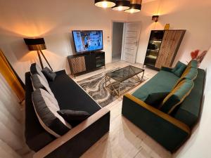 ein Wohnzimmer mit 2 Sofas und einem TV in der Unterkunft Aparthotel Zabrze, Apartament Agnieszka in Zabrze