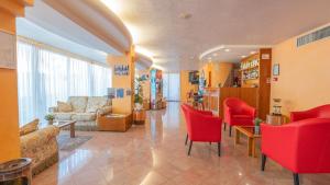 a living room with red chairs and a couch at Hotel Nobel in Rimini