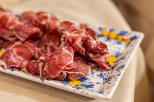 a plate of cooked bacon on a table at Adler Cavalieri Hotel-Private Spa & Gym in Florence