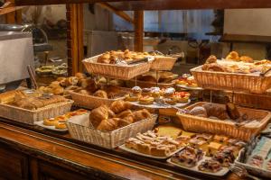 a buffet of pastries and breads in baskets at Adler Cavalieri Hotel-Private Spa & Gym in Florence